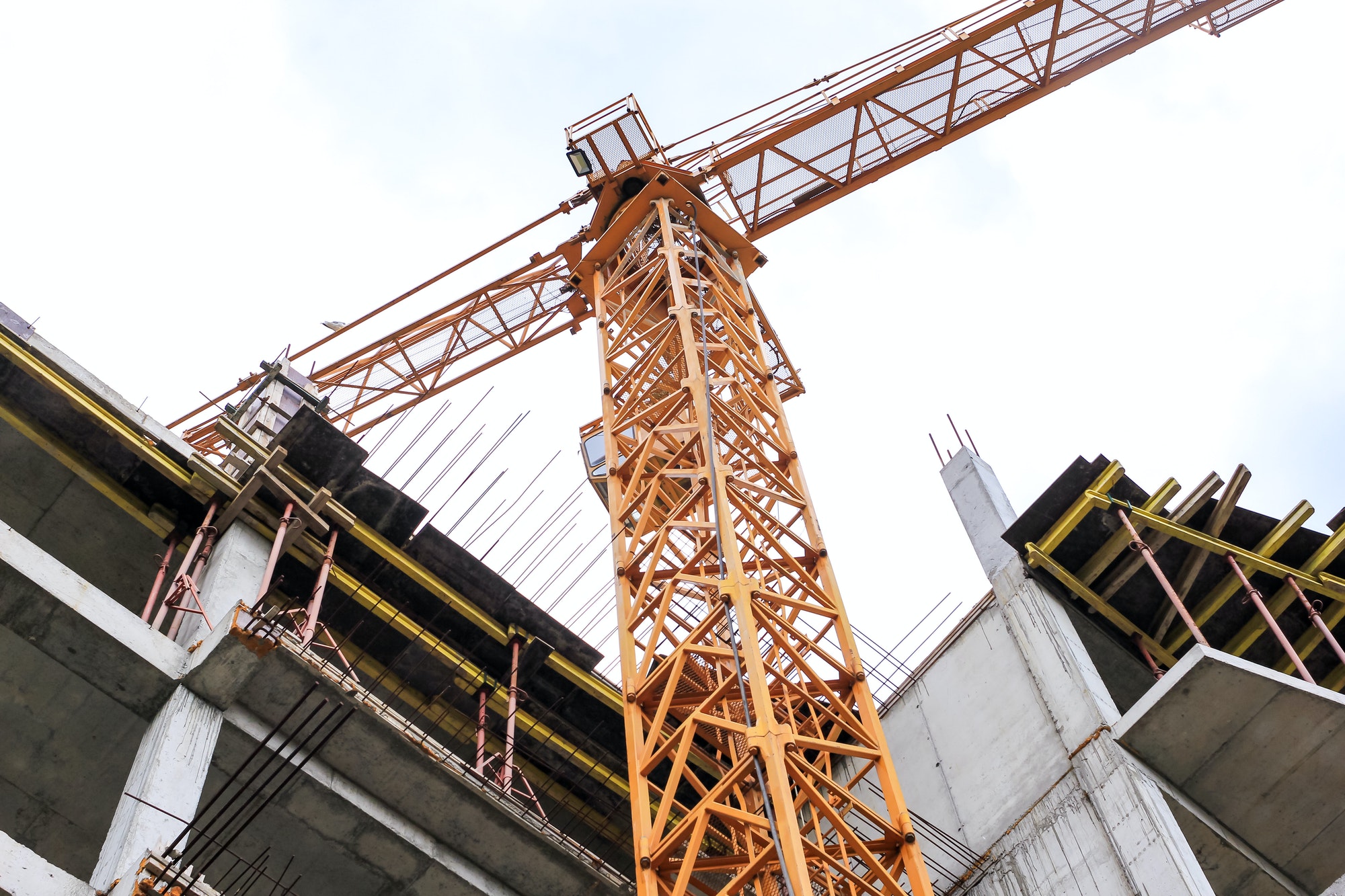 Construction crane stands on the background of the sky. Construction site. Tower crane.